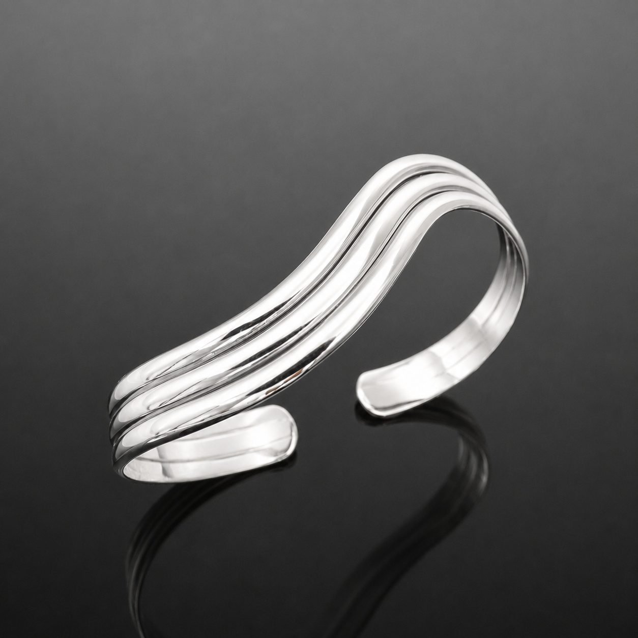 wavy_silver_cuff_bracelet_moon_jewellery_uk Three parallel wave lines mirrored sterling silver 925 cuff bracelet close up