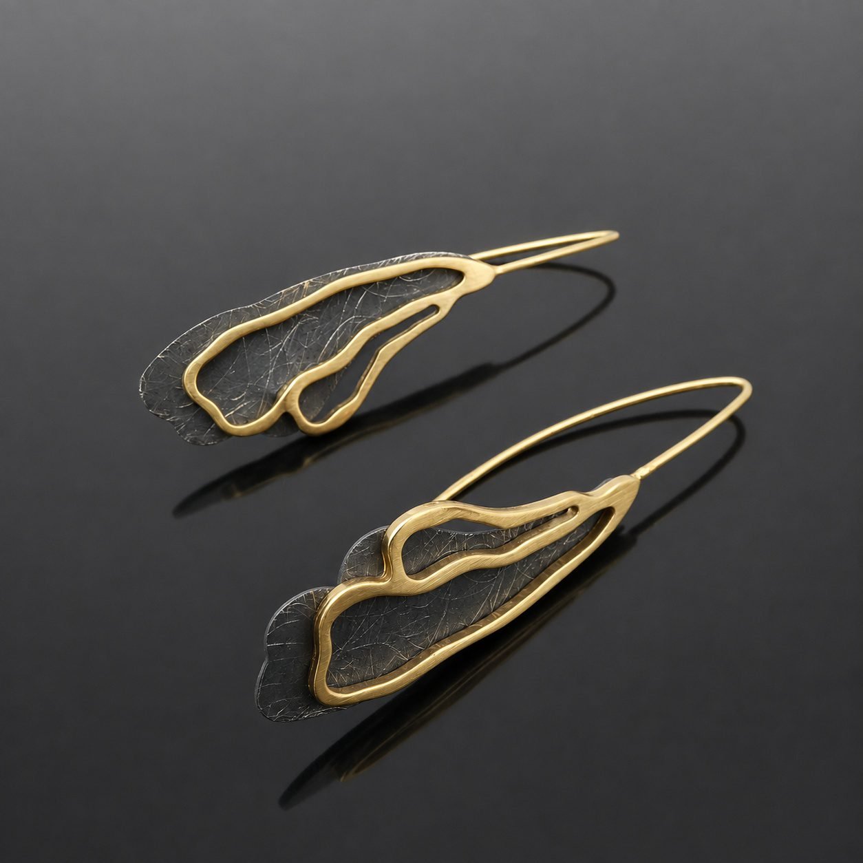 Ruthenised sterling silver deep black and brushed gold plated abstract curl earring close up